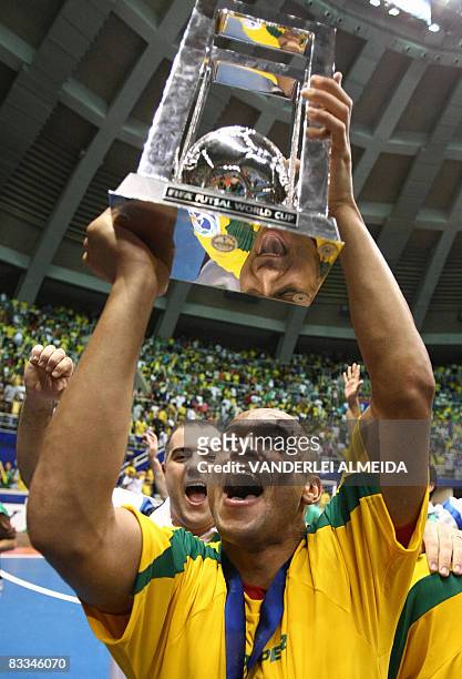 Brazil's futsal team player Cico celebrates with the trophy after defeating Spain to win the championship on October 19, 2008 in their FIFA Futsal...