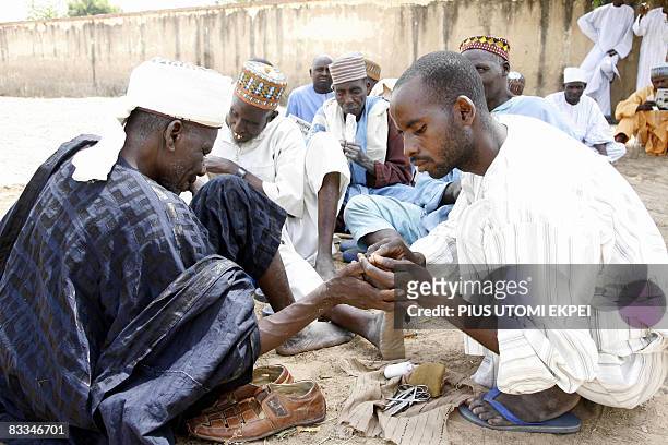 Man trims the finger nails of another for a fee at the historic first Talakawa Summit in Nigeria in Dutse, Jigawa State on October 18, 2008. Top...