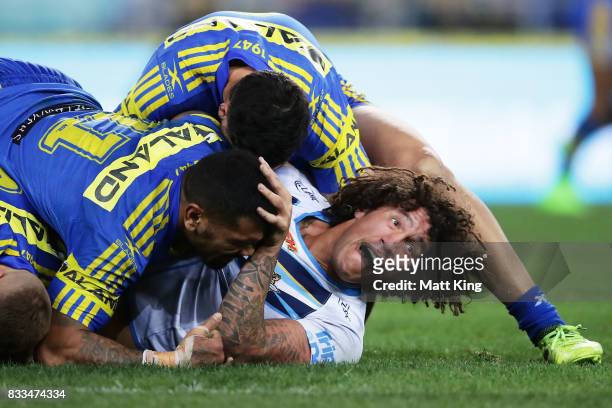 Kevin Proctor of the Titans is tackled during the round 24 NRL match between the Parramatta Eels and the Gold Coast Titans at ANZ Stadium on August...