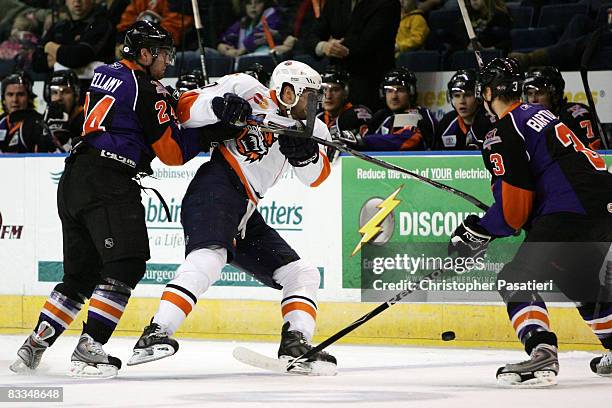 Rob Bellamy and Oskars Bartulis of the Philadelphia Phantoms check Jason Pitton of the Bridgeport Sound Tigers during the first period on October 19,...