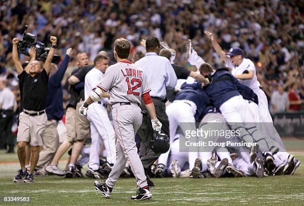 Jed Lowrie of the Boston Red Sox walks off the field as the Tampa Bay Rays celebrate winning game seven of the American League Championship Series...