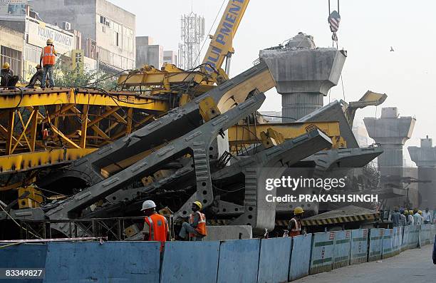 Heavy crane is used to clear wreckage of a crane and a bridge which was under construction as part of the development of the Delhi Metro in New Delhi...