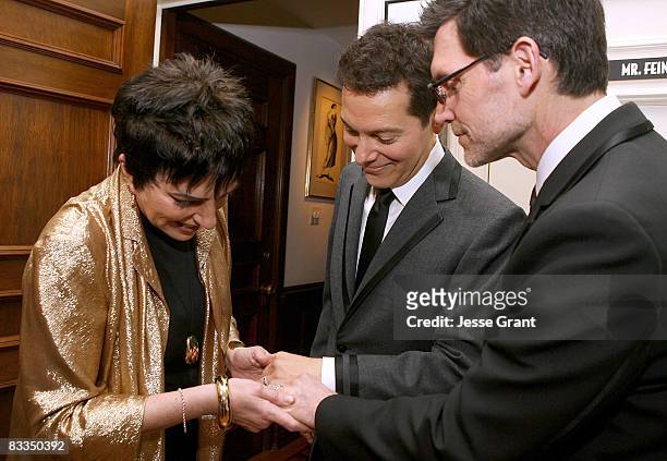 Liza Minnelli looks at Michael Feinstein and Terrence Flannery's wedding rings during their wedding ceremony held at a private residence on October...