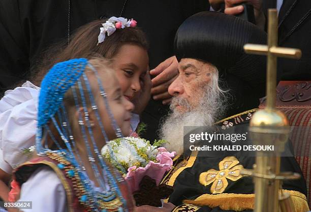 Pope Shenouda III , head of the Coptic Orthodox Church, Patriarch of Alexandria and the See of St. Mark, receives flowers from children during a...