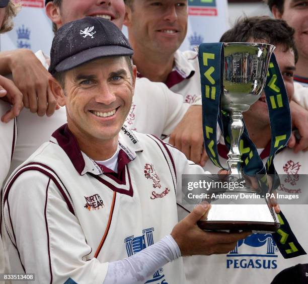 Somerset captain Justin Langer holds the trophy after Somerset win the second division title during day three of the LV County Championship Division...