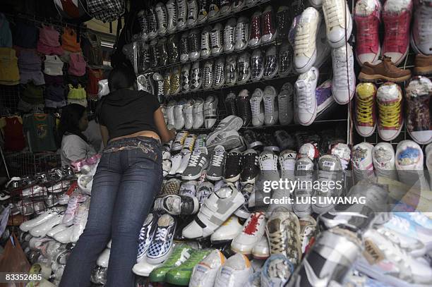 Vendor arranges assorted shoes at the Divisoria market in Manila on October 20, 2008. Rising cost of fuel and basic commodities are hitting Filipino...