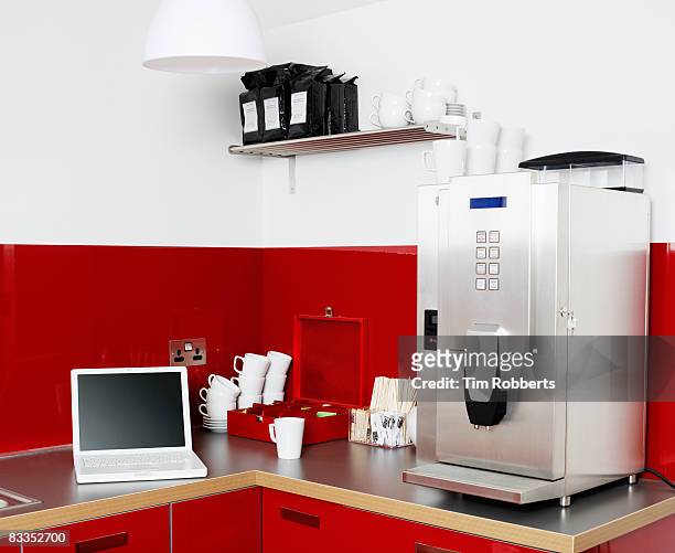 laptop and coffee machine in office kitchen - coffee maker stock pictures, royalty-free photos & images