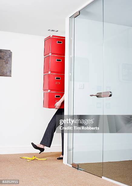 young woman about to slip on banana in office  - sabotage stock pictures, royalty-free photos & images