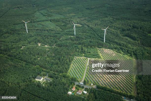 This aerial photo shows wind power stations next to a solar fields on August 04, 2017 in Bernsdorf, Germany..