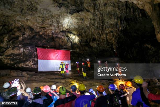 Indonesian citizens salute an Indonesian flag during a ceremony marking Indonesia's 72nd Independence Day inside the Jlamprong Cave in Yogyakarta,...