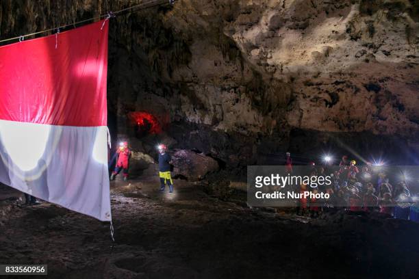 Indonesian citizens salute an Indonesian flag during a ceremony marking Indonesia's 72nd Independence Day inside the Jlamprong Cave in Yogyakarta,...