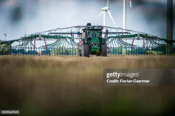 Tractor with a liquid-manure tanker and a rear-mounted injector fertilizes a field on August 14, 2017 in Goldbeck, Germany..