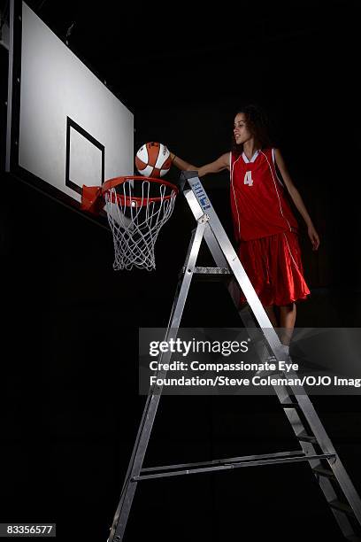 young lady stepping up the ladder to make a shot - step ladder stock pictures, royalty-free photos & images