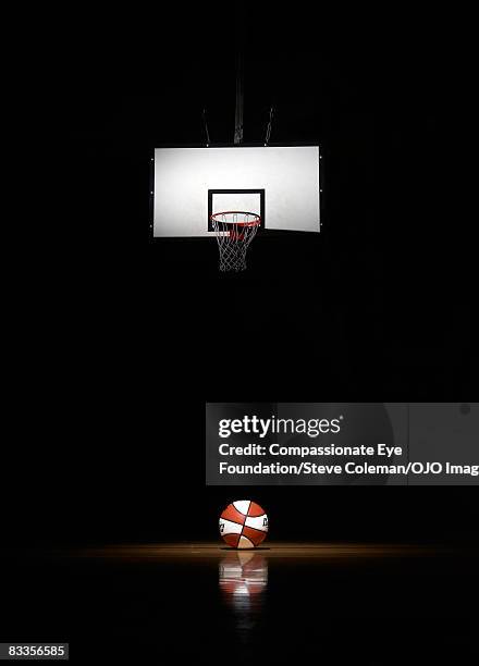 basketball in the spotlight, underneath the basket - basketball net stock pictures, royalty-free photos & images