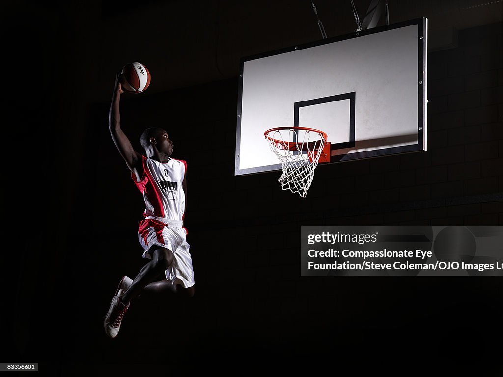 Young man in the air about to dunk the basketball