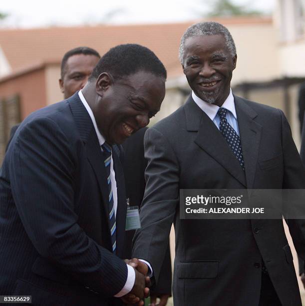 Former South African President Thabo Mbeki shakes hands with Zimbawe Rural Housing minister Emmerson Mnangagwa in Mbabane on October 20, 2008 before...