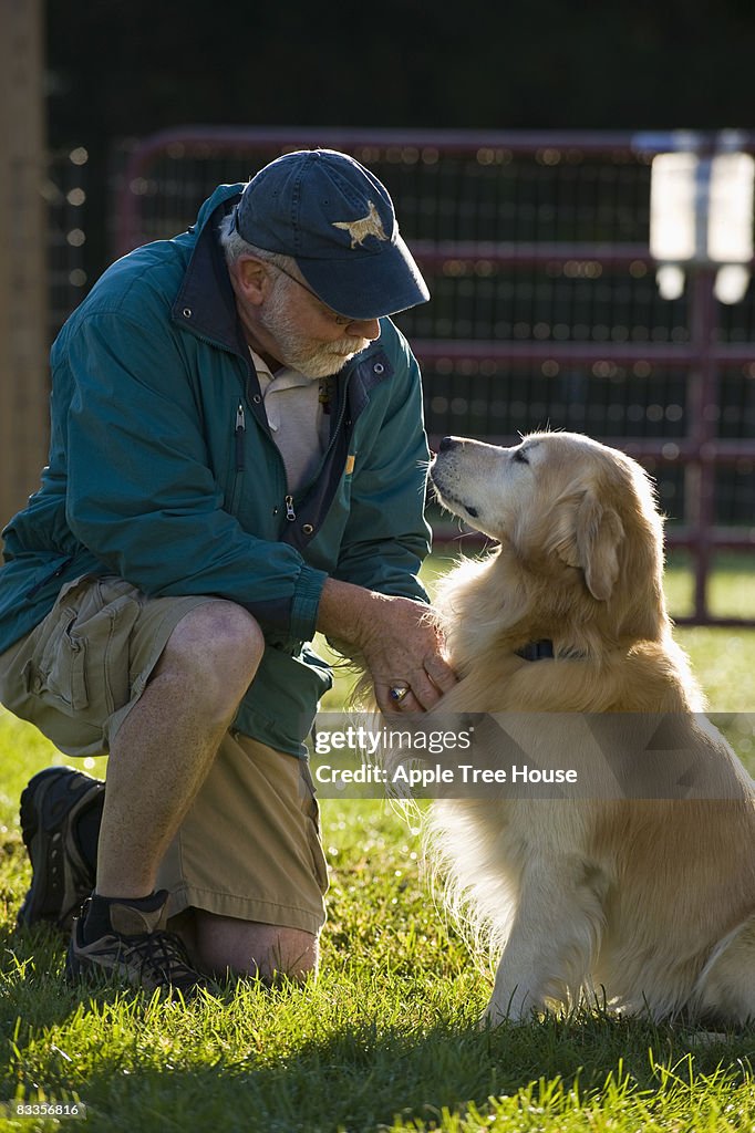 Man outdoors with Golden Retriever