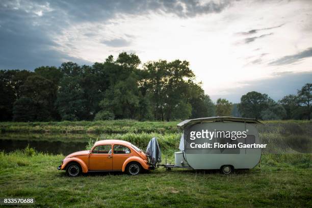 An old VW Kaefer with a caravan stands near the river Elbe on August 15, 2017 in Havelberg, Germany.