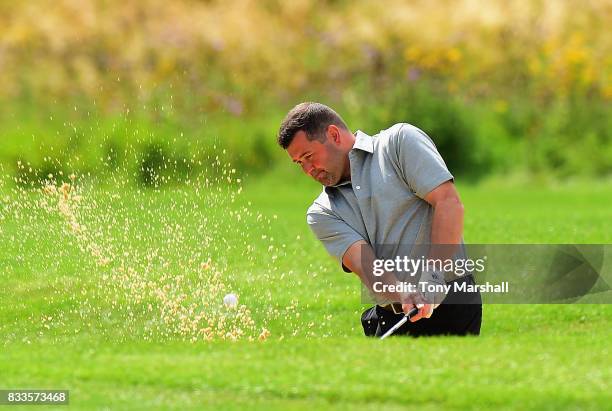 Mark Hancock of Stand Golf Club chips out of a bunker on the 18th green during the Golfbreaks.com PGA Fourball Championship - Day 2 at Whittlebury...