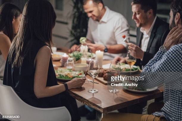 mooie groep vrienden eten diner samen. - four people stockfoto's en -beelden