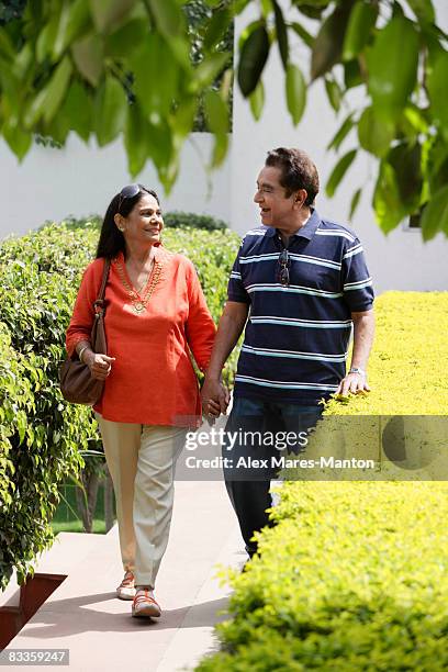 couple walking on path holding hands - hedge fonds stock pictures, royalty-free photos & images