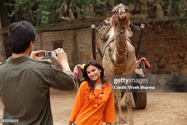 man taking photo of woman in front of camel - in front of camera stock pictures, royalty-free photos & images