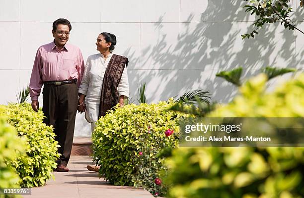 couple walking on garden path - hedge fonds stock pictures, royalty-free photos & images