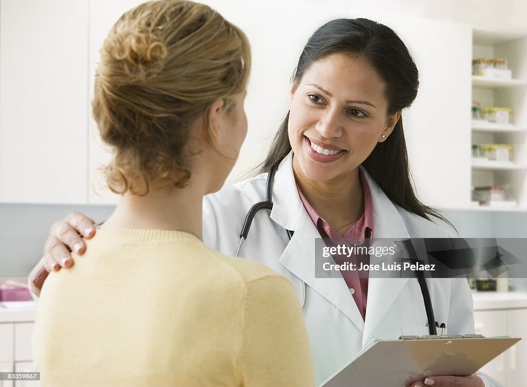 Female doctor putting hand on shoulder of patient