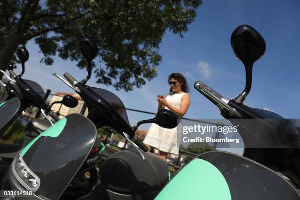 An employee uses a smartphone to book a Coup eScooter electric hire vehicle, operated by Robert Bosch GmbH, in Berlin, Germany, on Thursday, Aug. 17,...