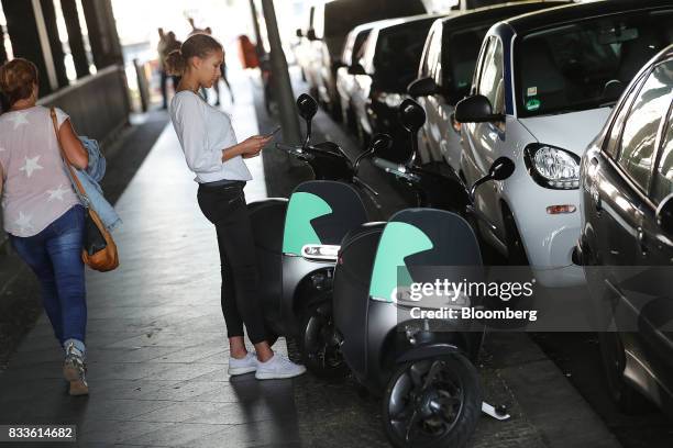 An employee uses a smartphone to book a Coup eScooter electric hire vehicle, operated by Robert Bosch GmbH, in Berlin, Germany, on Thursday, Aug. 17,...