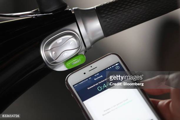 An employee uses a smartphone to book a Coup eScooter electric hire vehicle, operated by Robert Bosch GmbH, in Berlin, Germany, on Thursday, Aug. 17,...