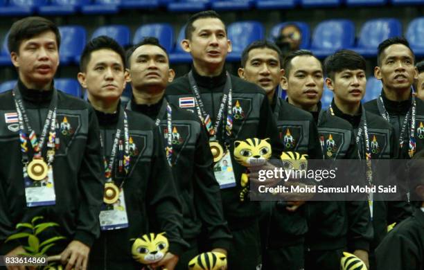 Thailand team respect their national anthem after winning the Sea Games Gold Medal during the Sepak Takraw Men's Chinlone category as part of the...