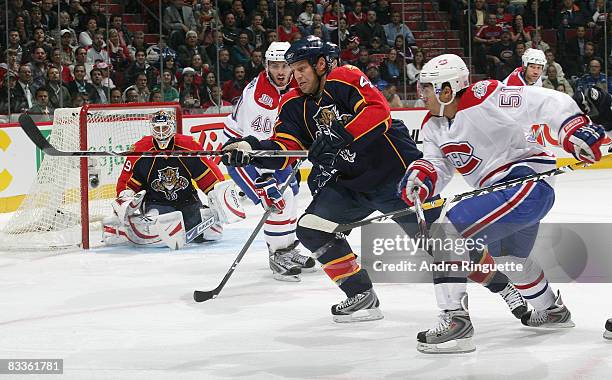 Nick Boynton of the Florida Panthers skates after a loose puck against pressure from Francis Bouillon and Maxim Lapierre of the Montreal Canadiens at...