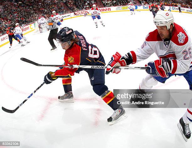 Mathieu Dandenault of the Montreal Canadiens battles for a loose puck long the boards with Michael Frolik of the Florida Panthers at the Bell Centre...