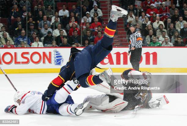 Tomas Vokoun of the Florida Panthers skates way out of his crease to cover a loose puck and collides with Guillaume Latendresse of the Montreal...