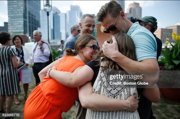 Boston Marathon bombing survivors Jessica Downes, left, and Patrick Downes, right, embrace fellow bombing survivor Jane Richard as her father Bill...