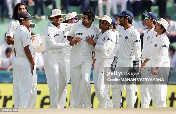 Indian cricketer Zaheer Khan celebrates with teammates after taking the wicket of Australian cricketer Brett Lee during the fifth day of the second...