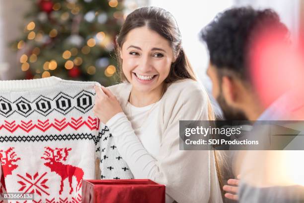 junge frau zeigt enttäuschung in weihnachtsgeschenk - enttäuscht stock-fotos und bilder