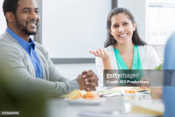 cheerful businesswoman updates colleagues during meeting - lunch stock pictures, royalty-free photos & images