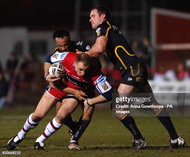 Hull KR's Jim Gannon tackled by Leeds rhinos Jamie Jones Buchanan and Jamie Peacock during the engage Super League match at Craven Park, Hull.