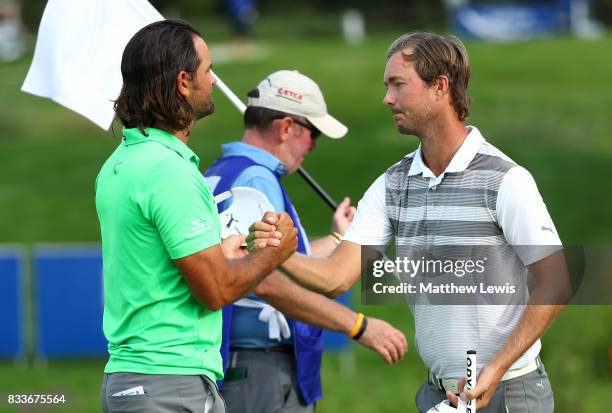 Jens Fahrbring of Sweden is congratulated by Johan Edfors of Sweden after winning his match on the 17th green during round one of the Saltire Energy...