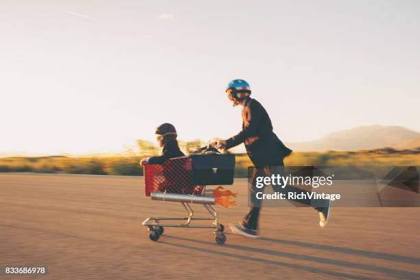 carrello della spesa young businessmen racing rocket - helmet cart foto e immagini stock