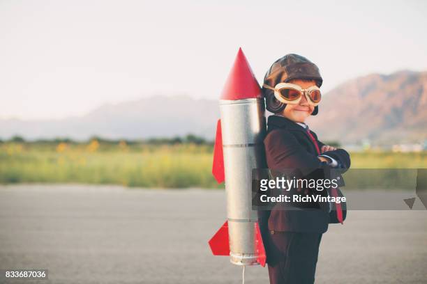 young business boy with rocket on back - launch event stock pictures, royalty-free photos & images