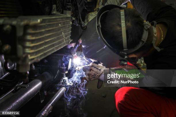 Worker tig welding to bumper repair at mohenic garages in Paju, South Korea. A 20-year-old beat up Hyundai SUV isn't anyone's idea of a dream car....