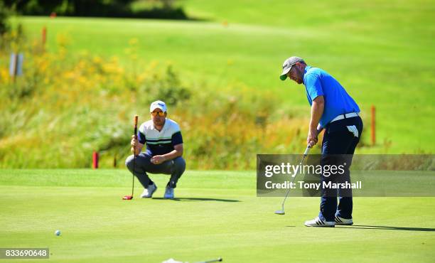 Daniel Beattie of Deer Park Hotel Golf and Spa watches Mark Whelan of Castlewarden Golf & Country Club putt on the 2nd green during the...