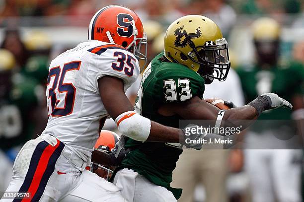 Running back Jamar Taylor of the South Florida Bulls runs from defender Mike Holmes of the Syracuse Orange during the game at Raymond James Stadium...