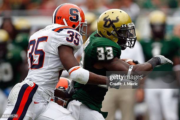 Running back Jamar Taylor of the South Florida Bulls runs from defender Mike Holmes of the Syracuse Orange during the game at Raymond James Stadium...