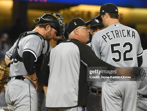 Kevan Smith of the Chicago White Sox looks on as manager Rick Renteria talks with pitcher Jake Petricka during the game against the Los Angeles...