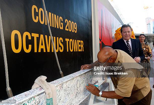 Caesars Palace General Manager John Unwin looks on as Clyde "Rabbit" Watkins, employee since opening day in 1966, signs the final beam of the...