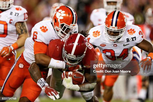 Linebackers Dorian O'Daniel and Kendall Joseph of the Clemson Tigers bring down Runningback Bo Scarbrough of the Alabama Crimson Tide during the 2017...